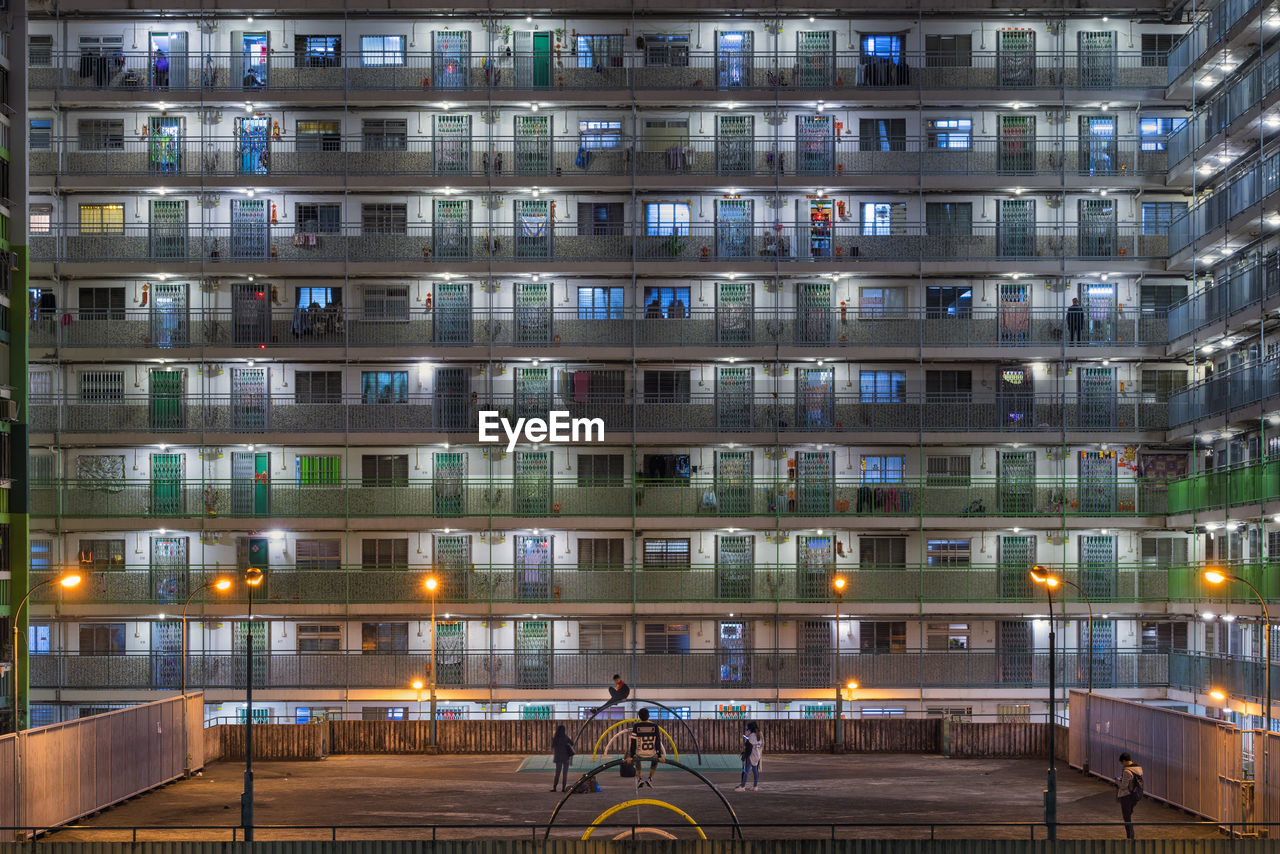 Public park against buildings in city at night