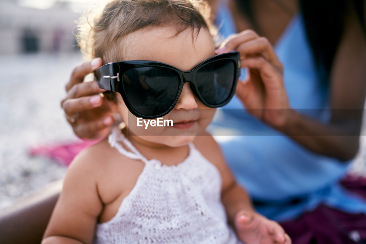 Midsection of woman holding sunglasses