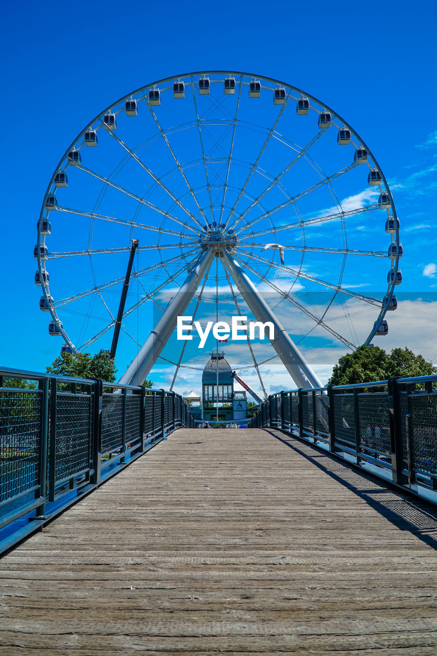 VIEW OF FERRIS WHEEL AGAINST BLUE SKY