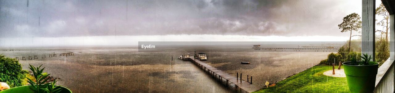 Panoramic view of boat moored by jetty in sea against sky at woodlawn beach