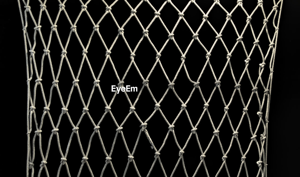 FULL FRAME SHOT OF CHAINLINK FENCE AT NIGHT
