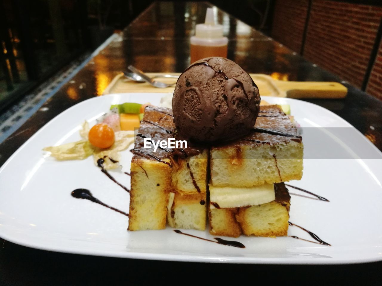 CLOSE-UP OF SERVED ICE CREAM IN PLATE ON TABLE