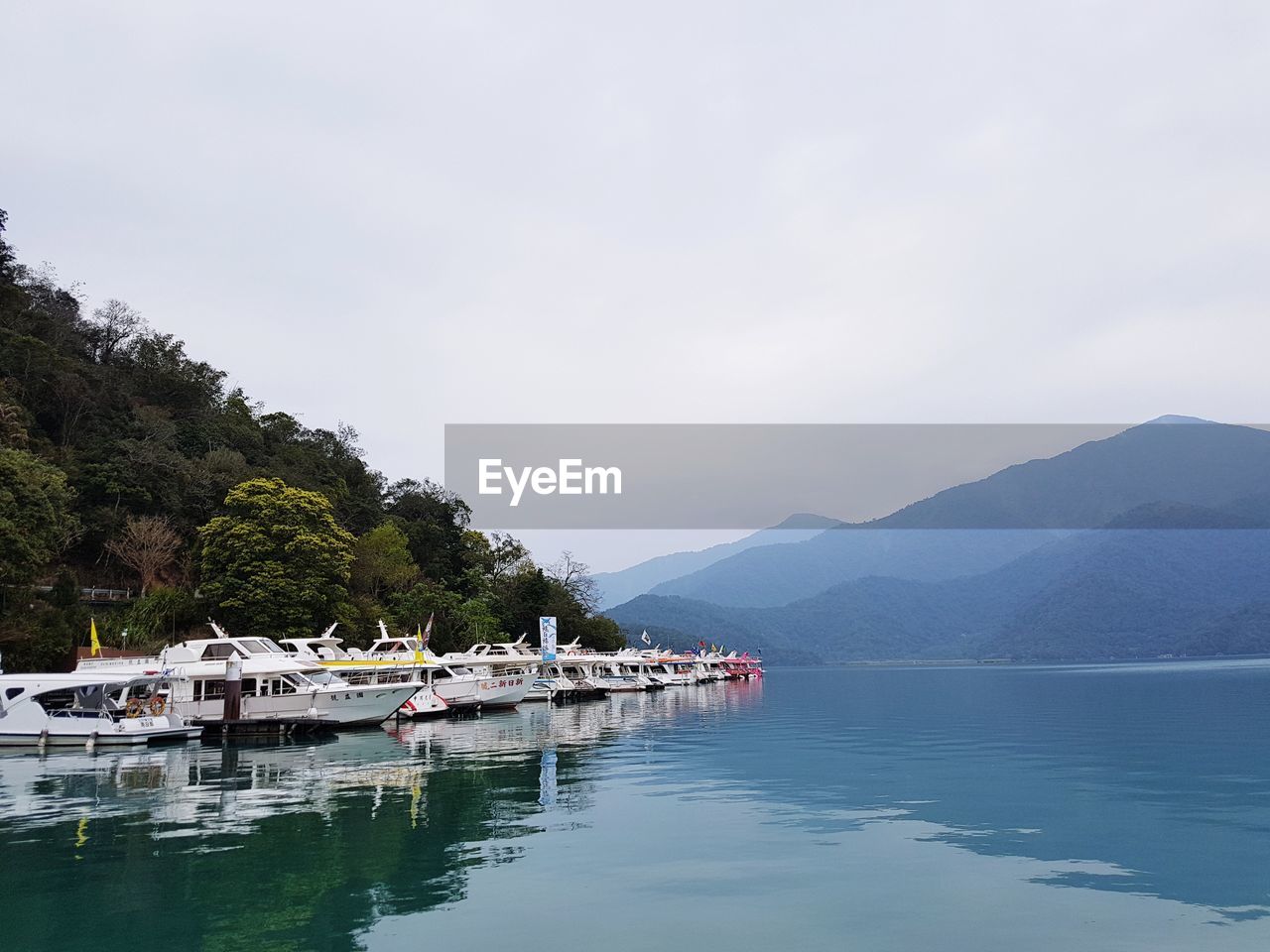 BOATS IN LAKE AGAINST SKY