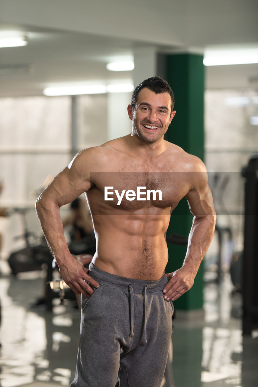 Portrait of smiling shirtless man standing in gym