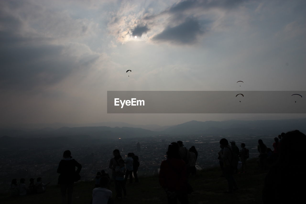 People on mountain against sky during sunset