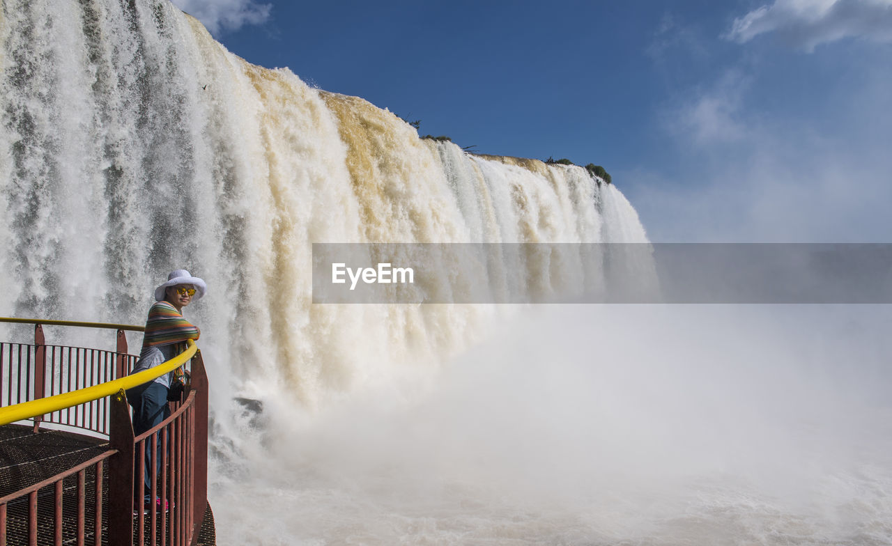 Woman in front of the iguacu waterfalls in brazil