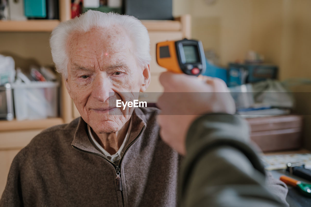 Portrait of man using mobile phone at home