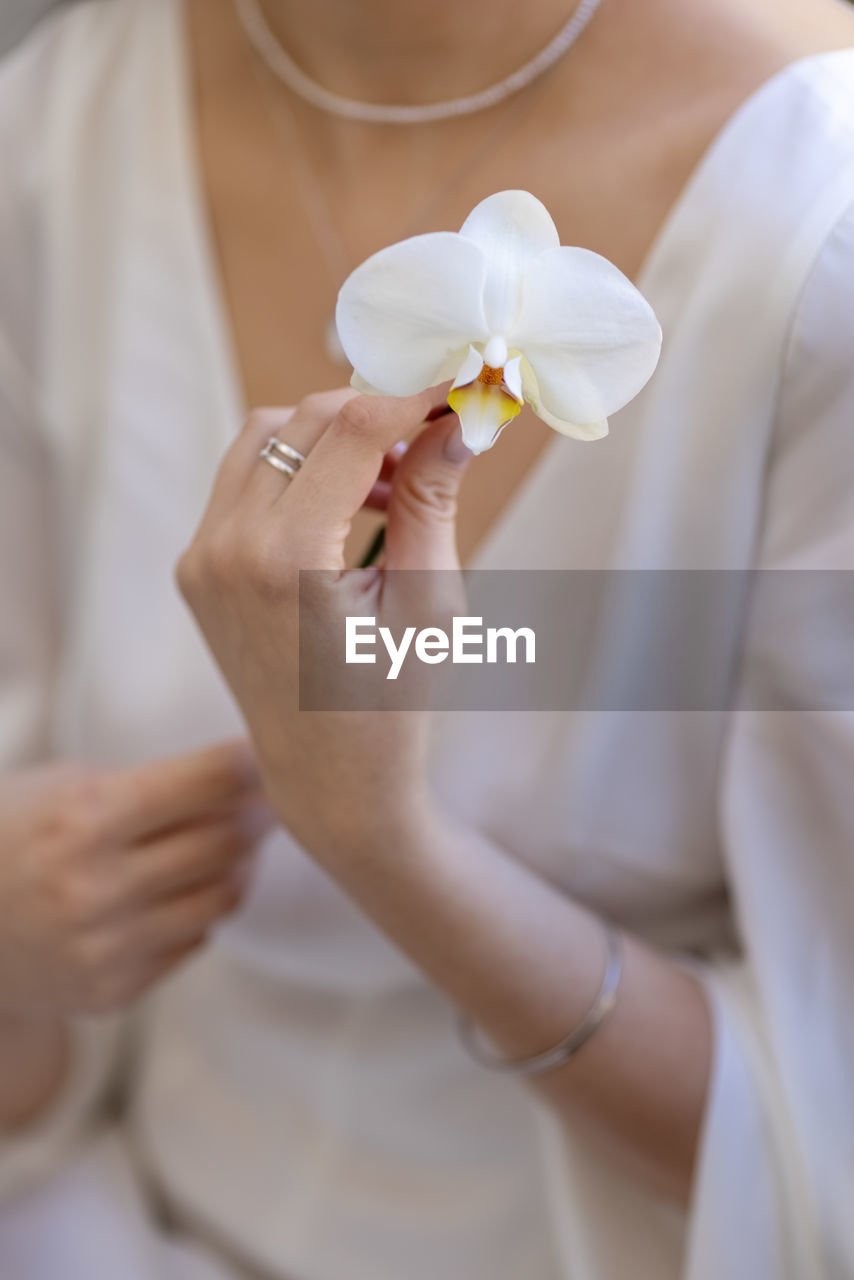 midsection of woman holding flower bouquet