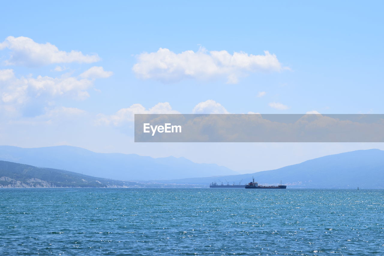 SCENIC VIEW OF SEA BY MOUNTAINS AGAINST SKY