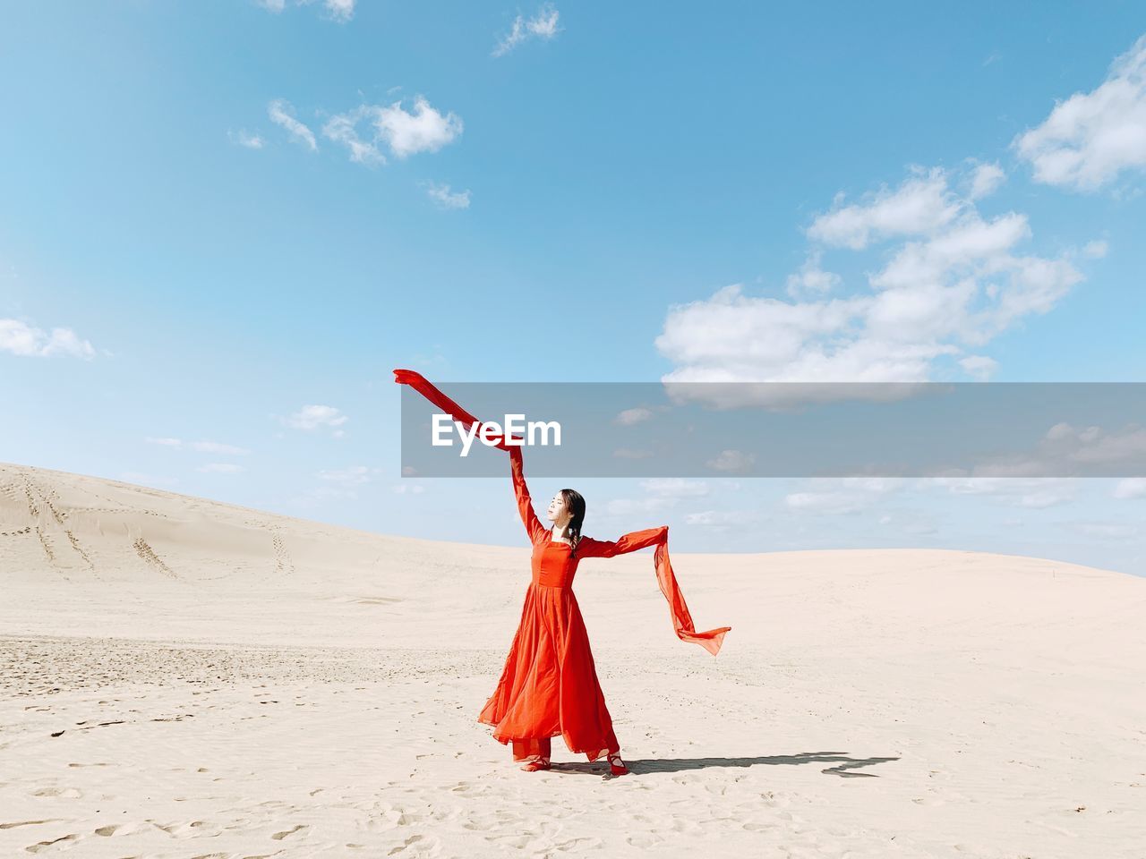 WOMAN WITH RED UMBRELLA ON BEACH