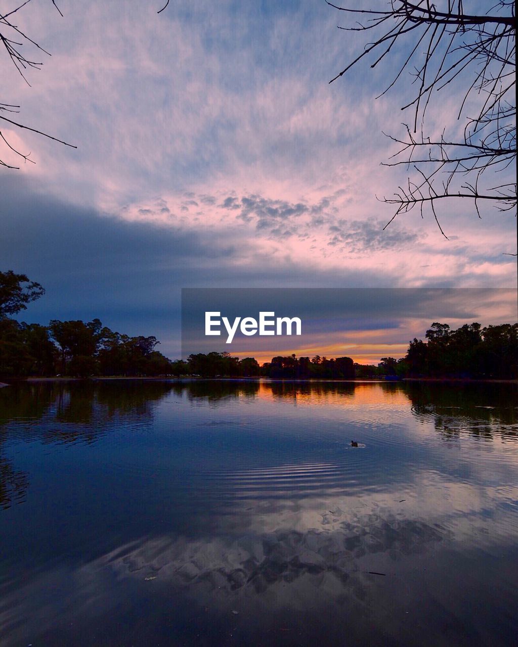 Scenic view of lake against sky at sunset