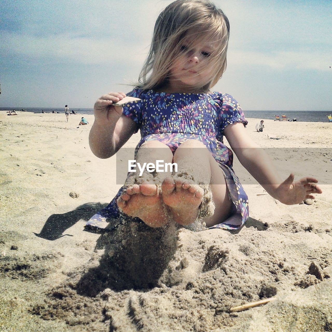 Full length of a girl playing in sand at beach