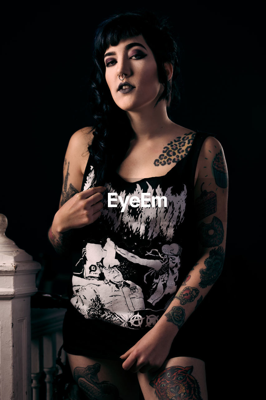 Portrait of tattooed young woman at home