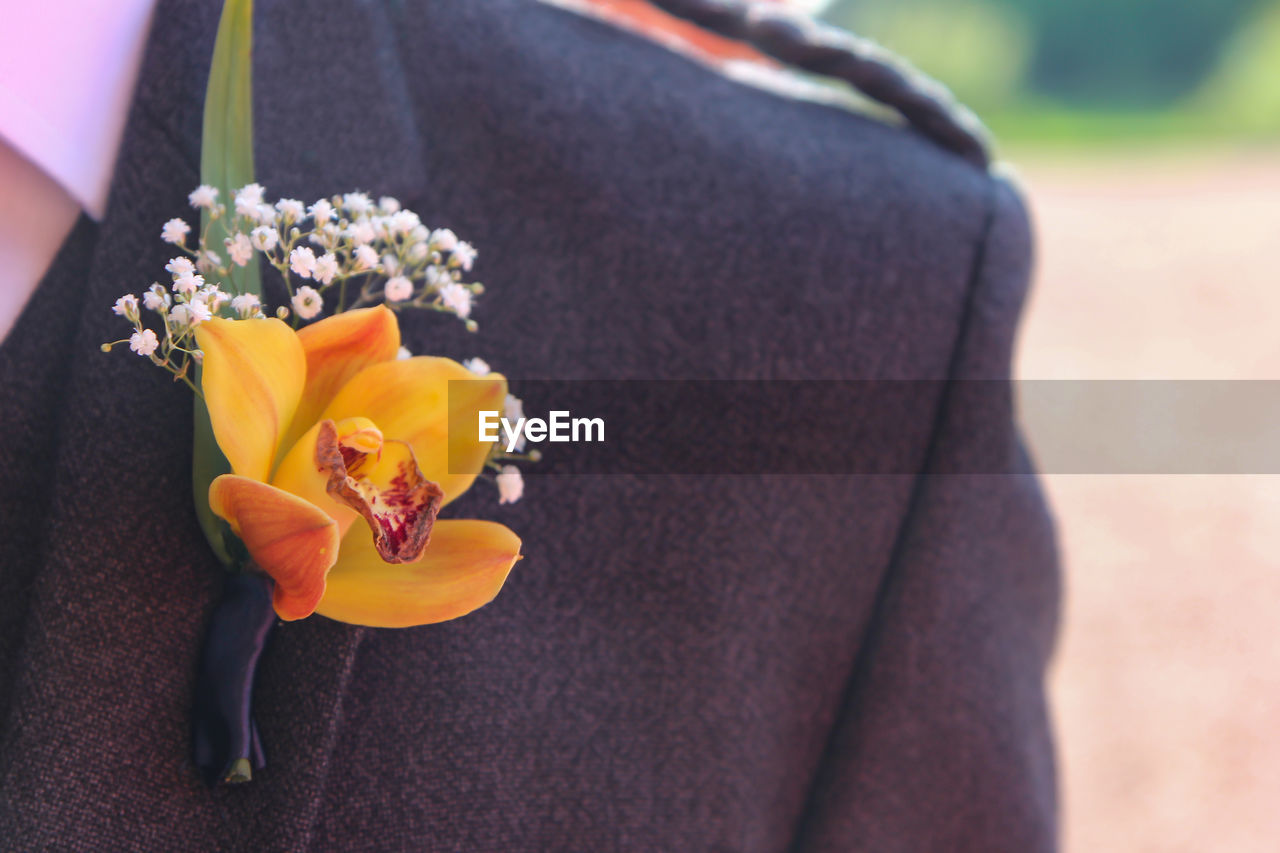 Close-up of flower button hole on groom at wedding