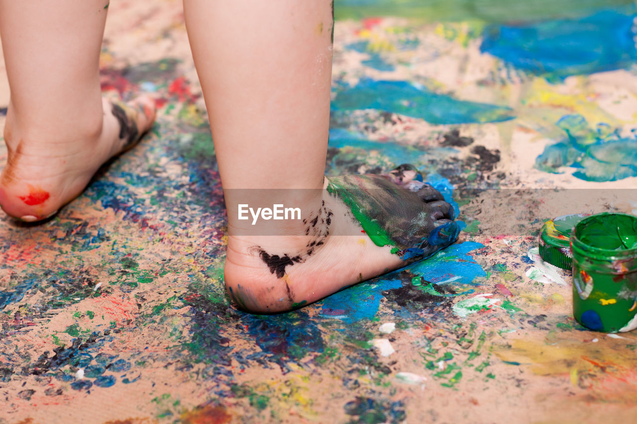 Little girl walking barefoot on fresh paint