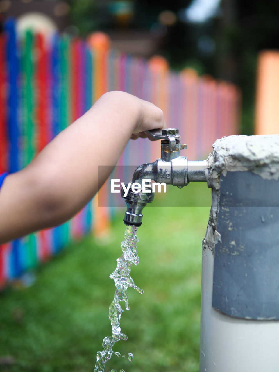 Cropped image of boy closing faucet