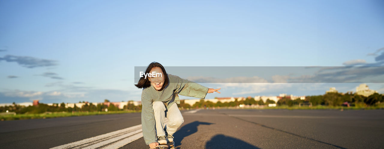 rear view of woman walking on road against clear sky