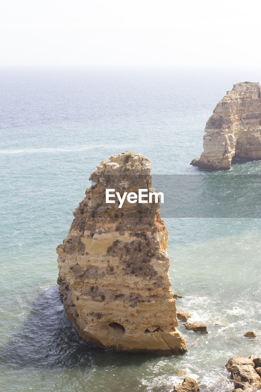 ROCK FORMATIONS IN SEA AGAINST SKY