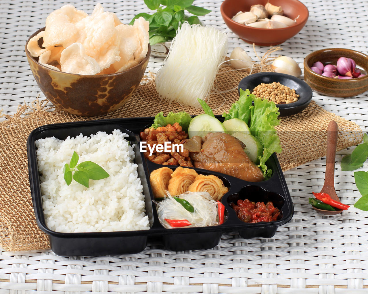 Rice box or nasi berkat, indonesian nasi kotak with soy sauce chicken, oreg tempeh, and spicy paste