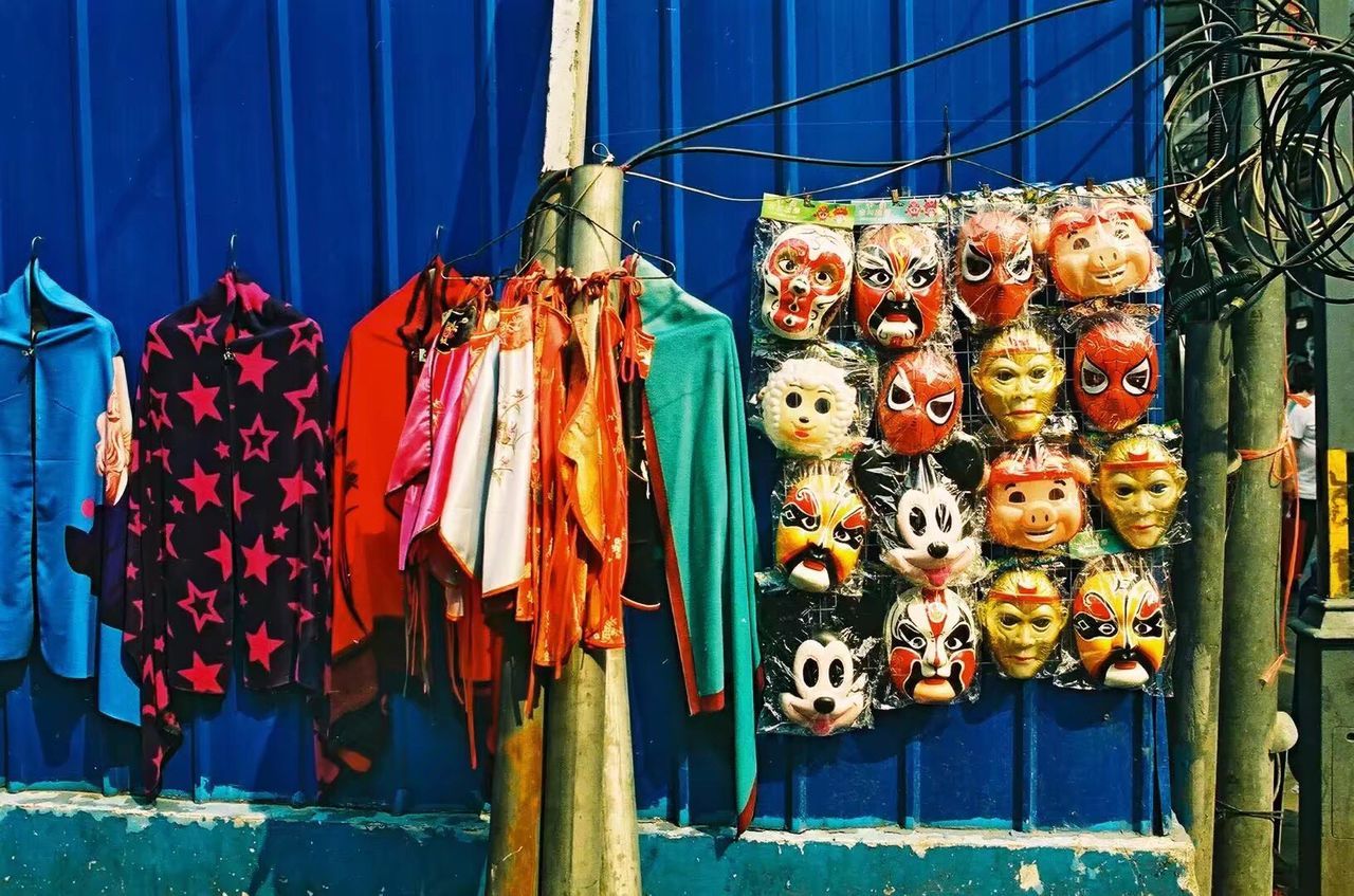 Clothes and mask hanging at market for sale