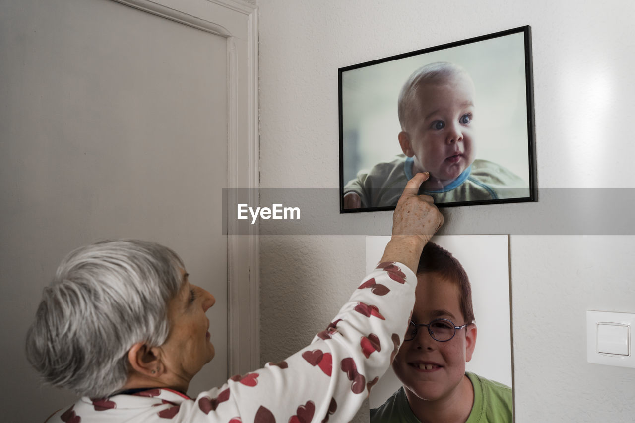 Grandmother with broken arm looking at pictures of her grandson