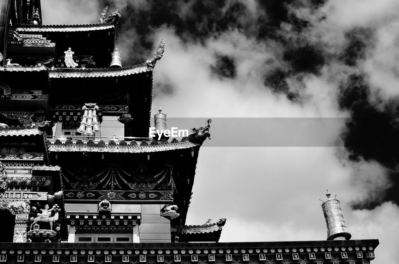 Low angle view of buddhist temple against cloudy sky