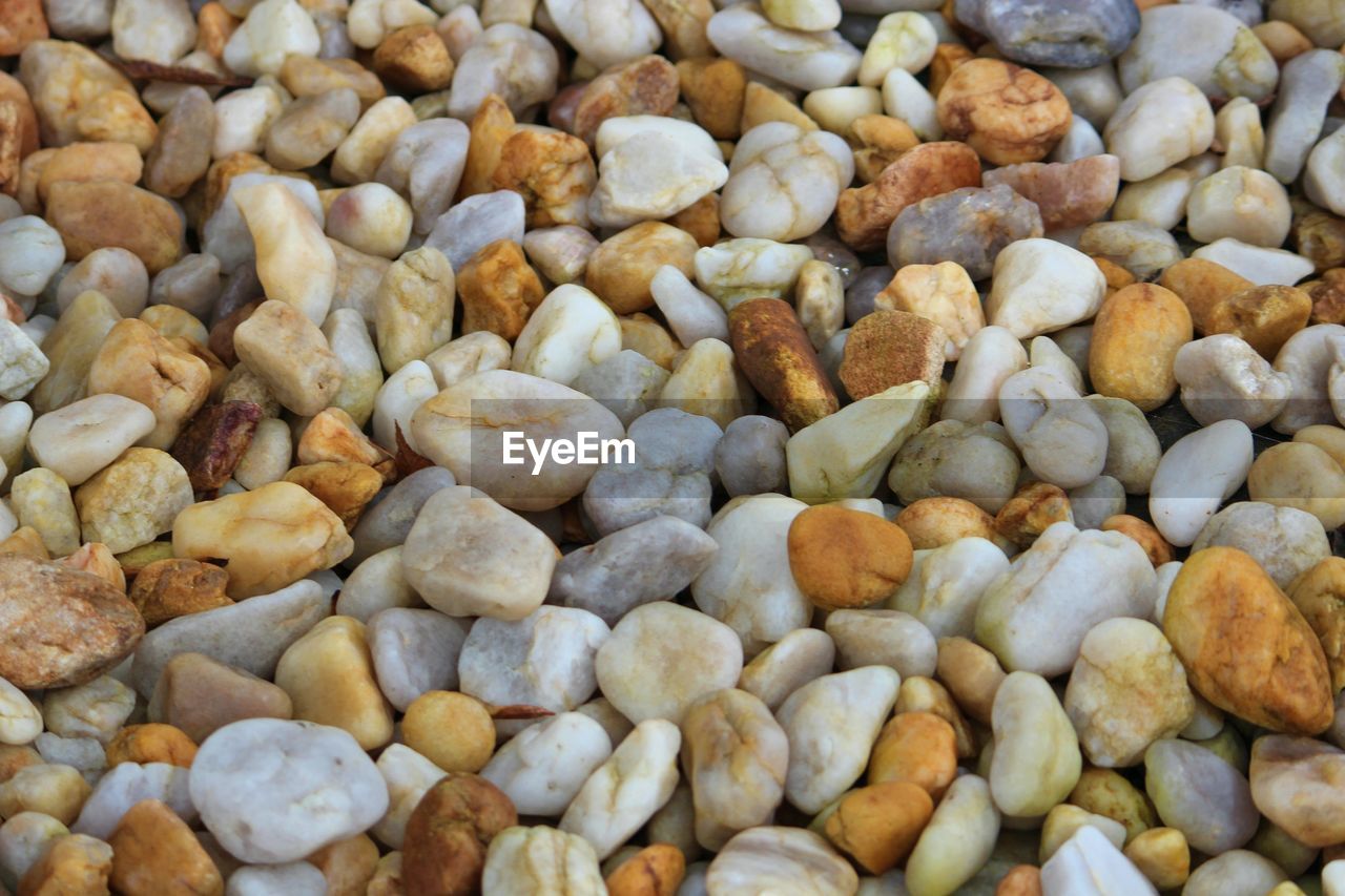 FULL FRAME SHOT OF PEBBLES ON ROCKS