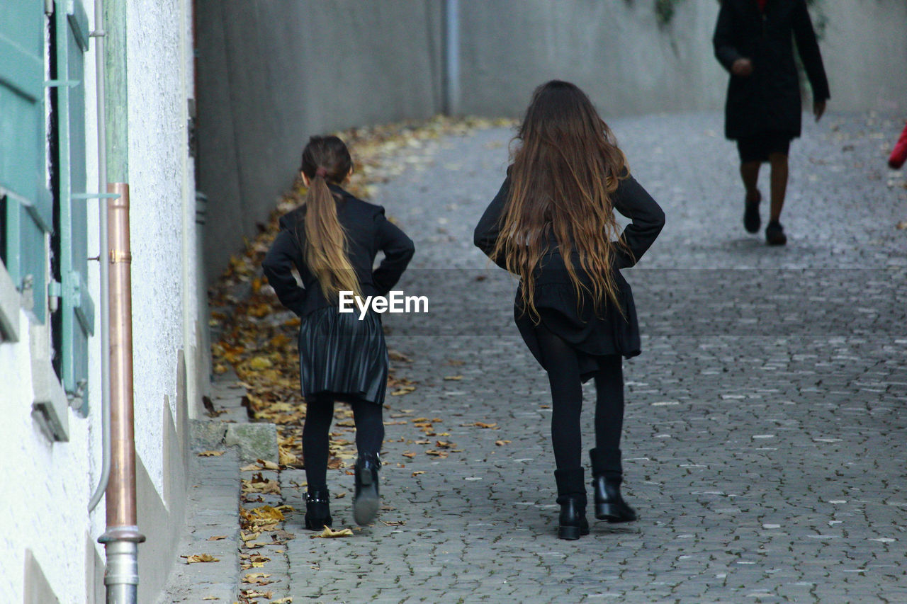 Rear view of women walking on footpath