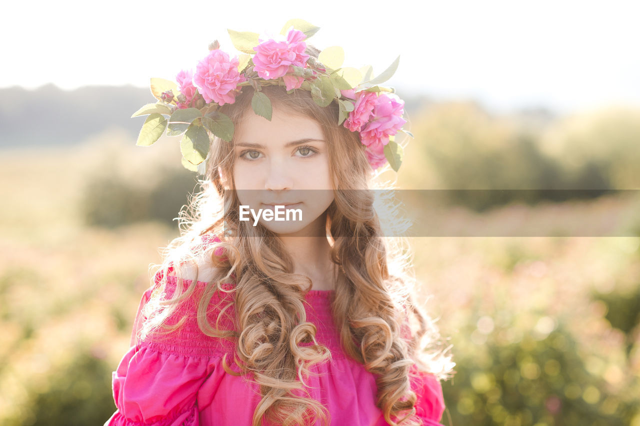 Portrait of teenager girl wearing wreath at farm