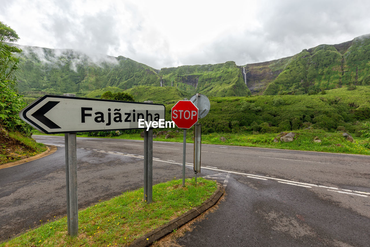 ROAD SIGN AGAINST MOUNTAINS