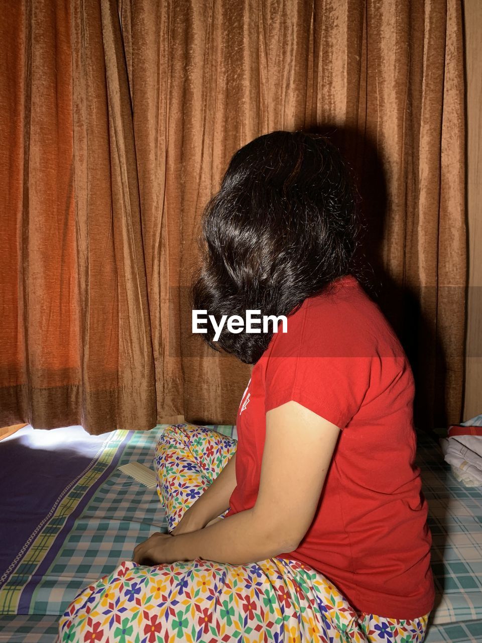 WOMAN SITTING ON BED