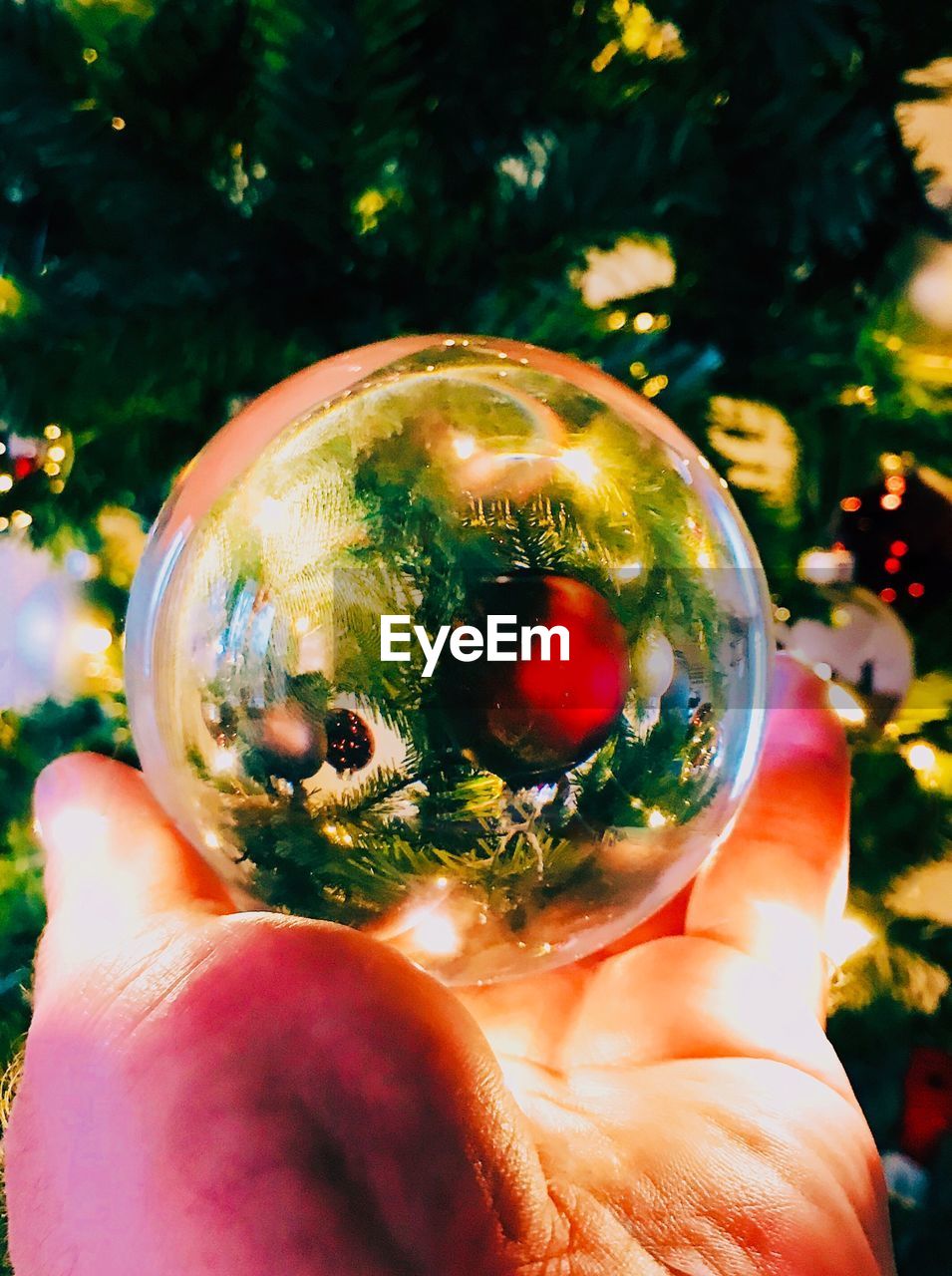 CLOSE-UP OF PERSON HAND HOLDING CRYSTAL BALL