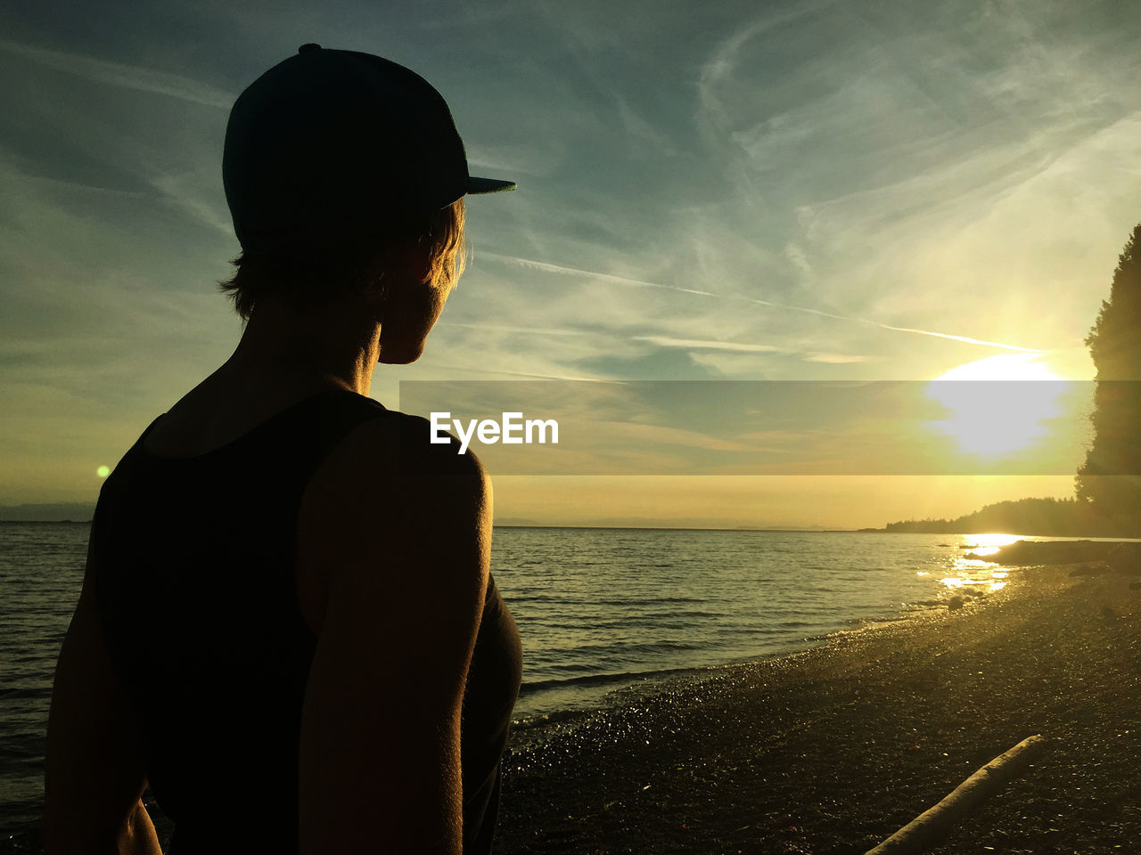 SILHOUETTE MAN LOOKING AT SEA DURING SUNSET