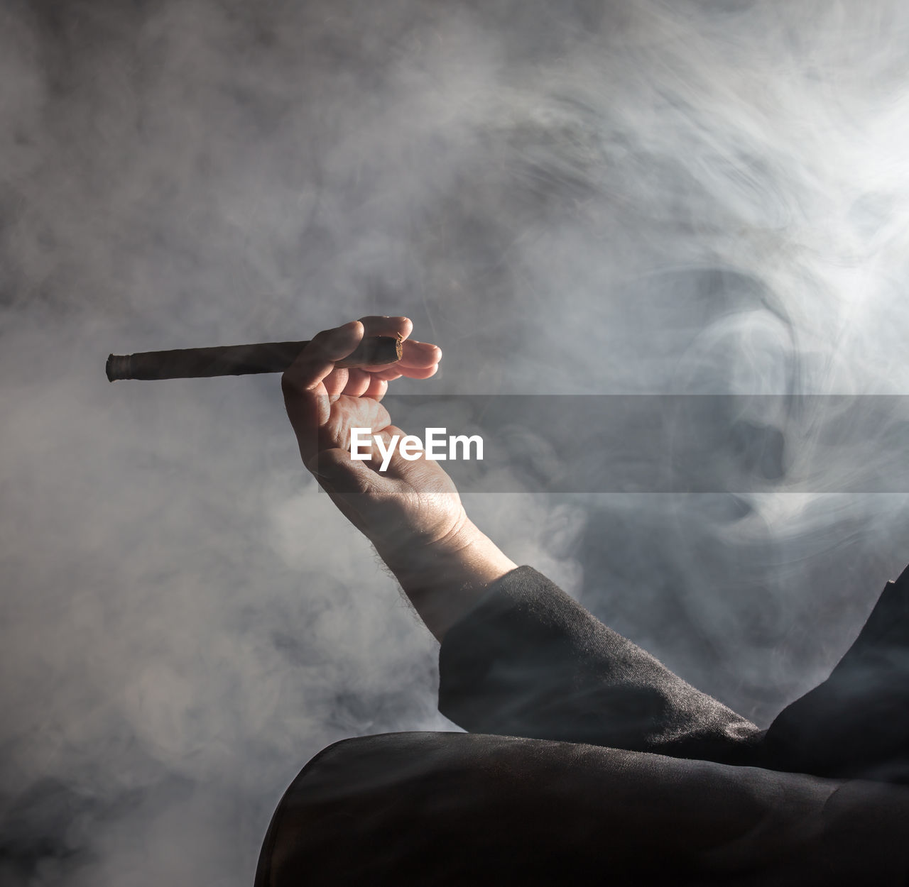 Close-up of man holding cigar