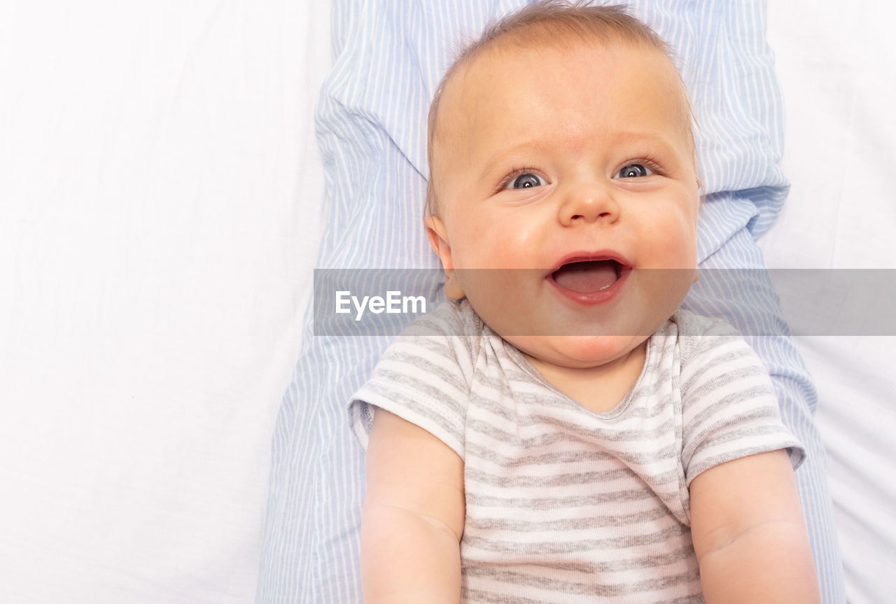 portrait of cute baby boy lying on bed