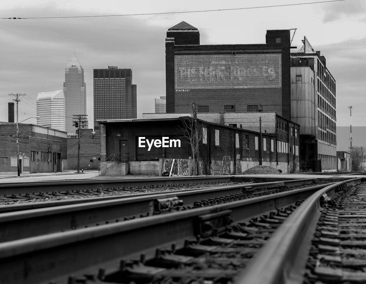 Railroad tracks in city against sky