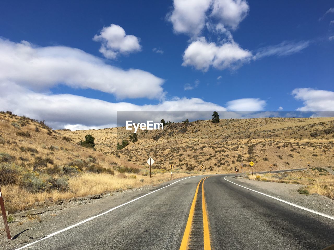 EMPTY ROAD ALONG LANDSCAPE AND AGAINST SKY