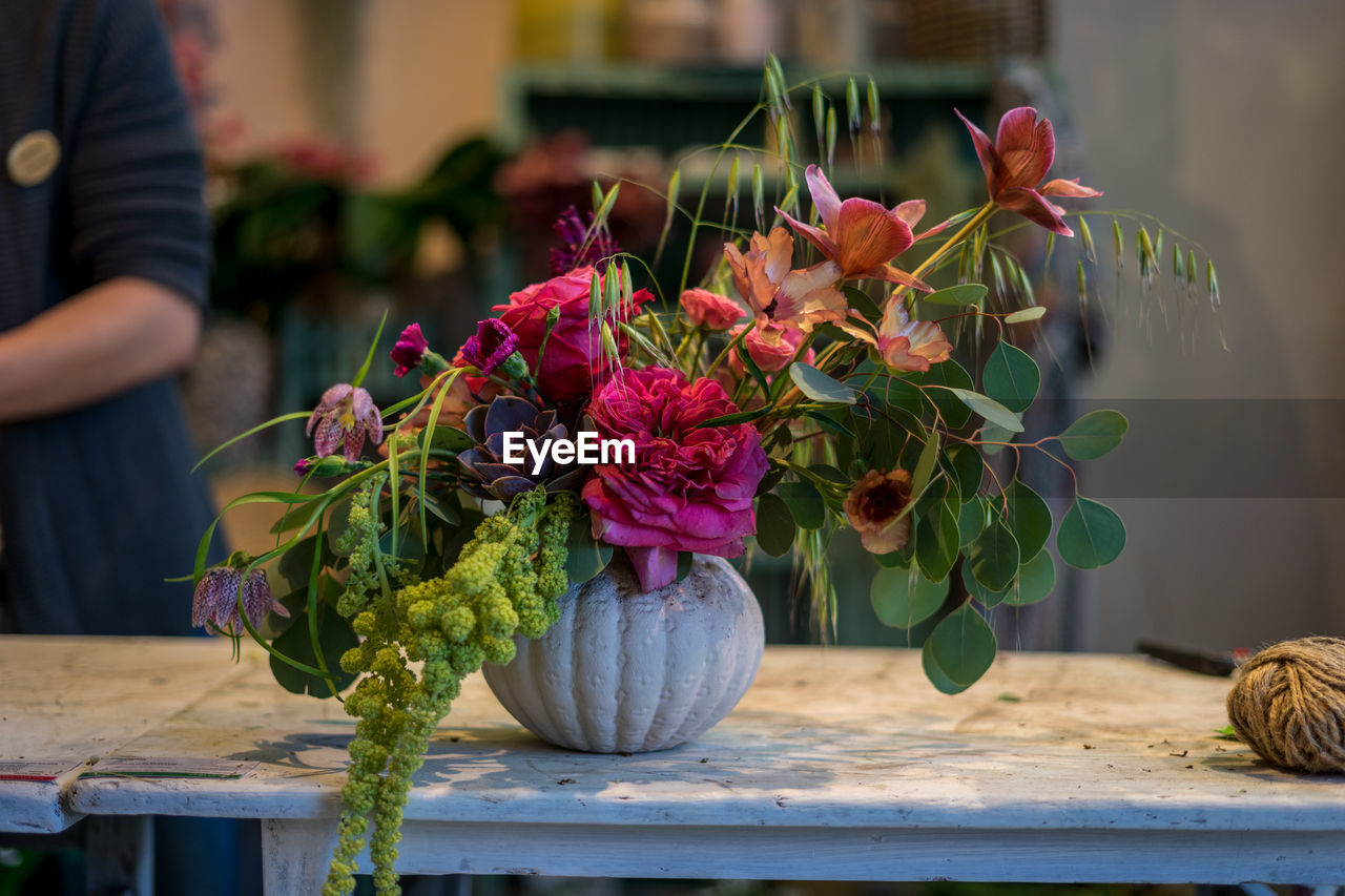 CLOSE-UP OF PINK FLOWERING PLANT IN VASE ON TABLE