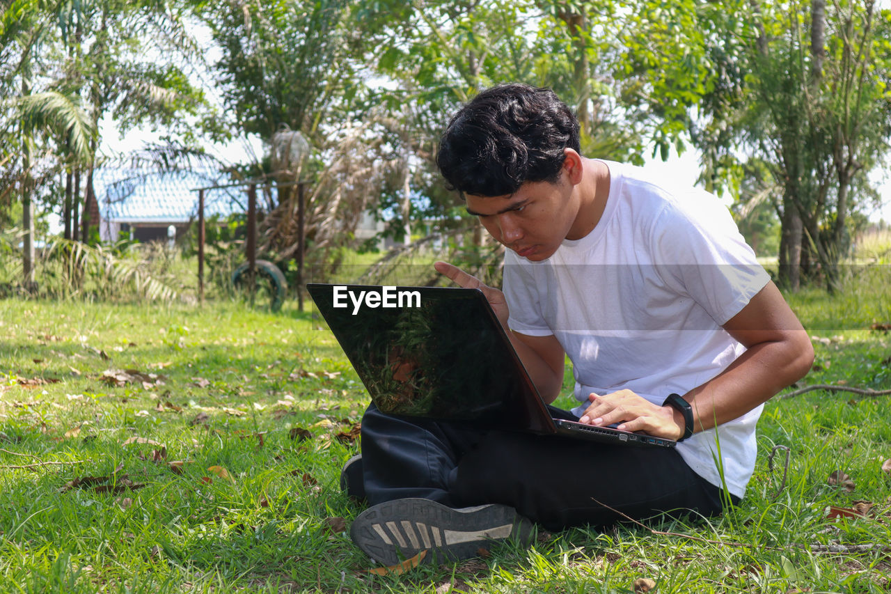 Young man sitting on field