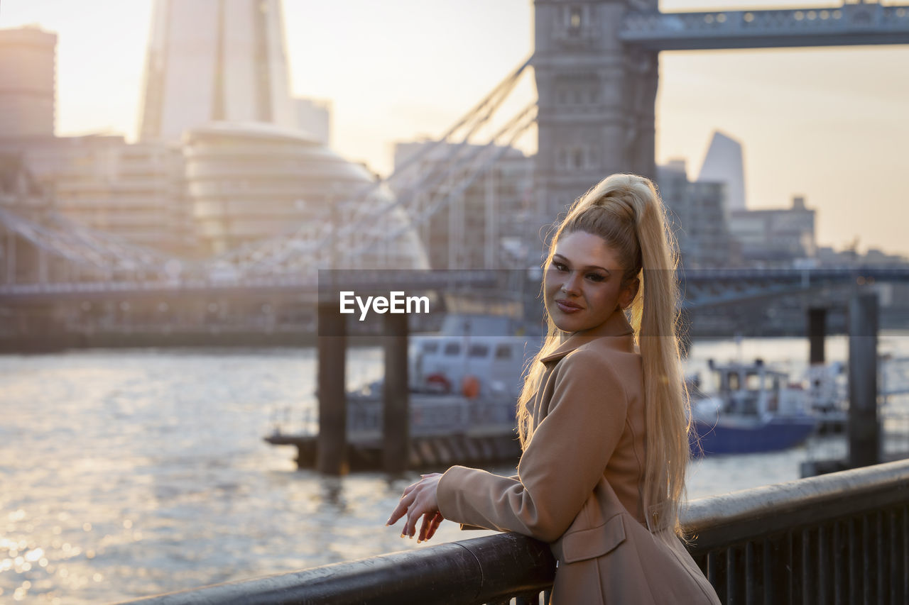 Portrait of young woman standing in city