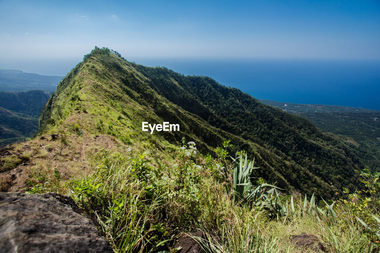 Scenic view of sea and mountains against sky