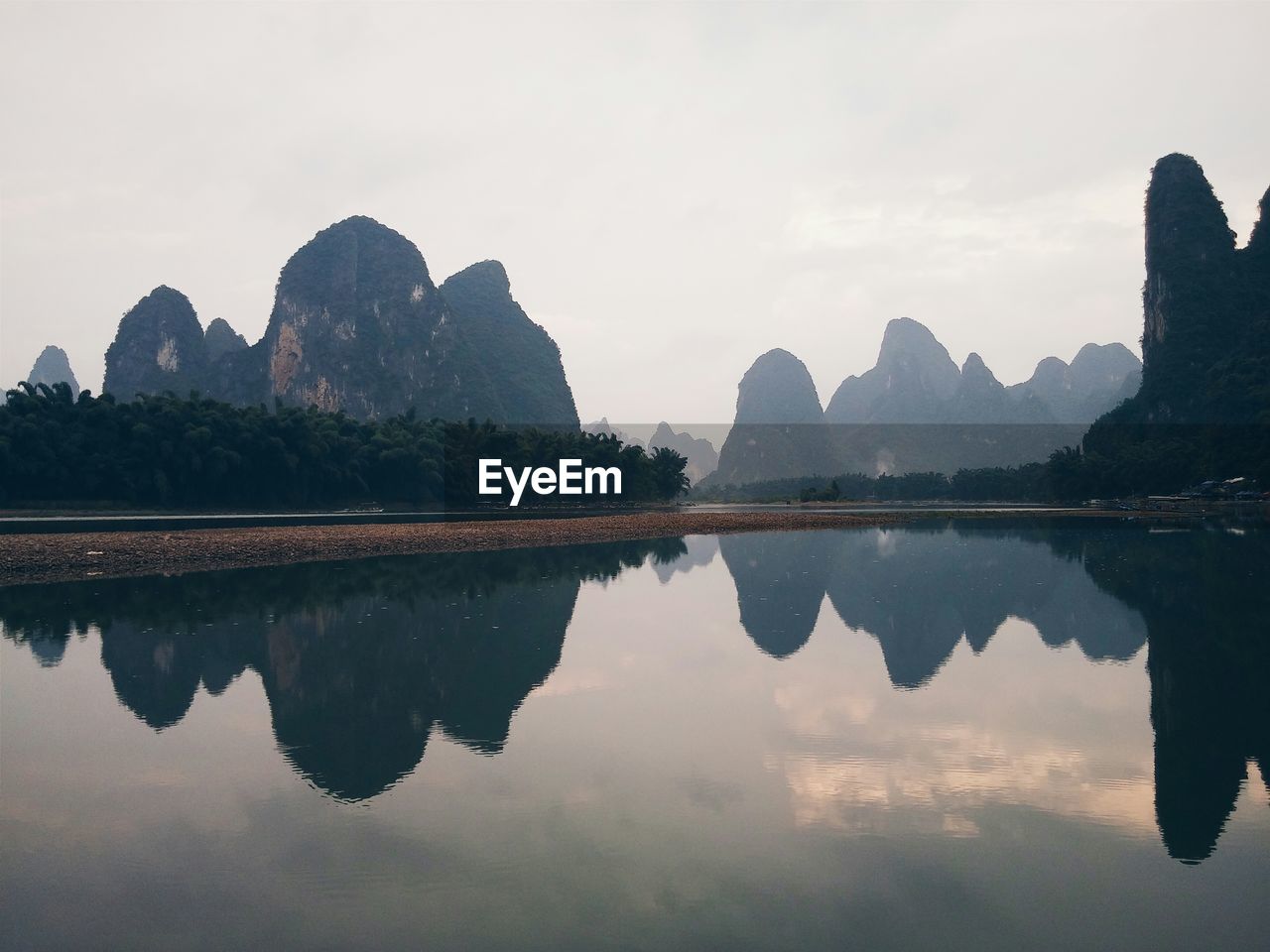 Karst mountains reflecting on li river against clear sky