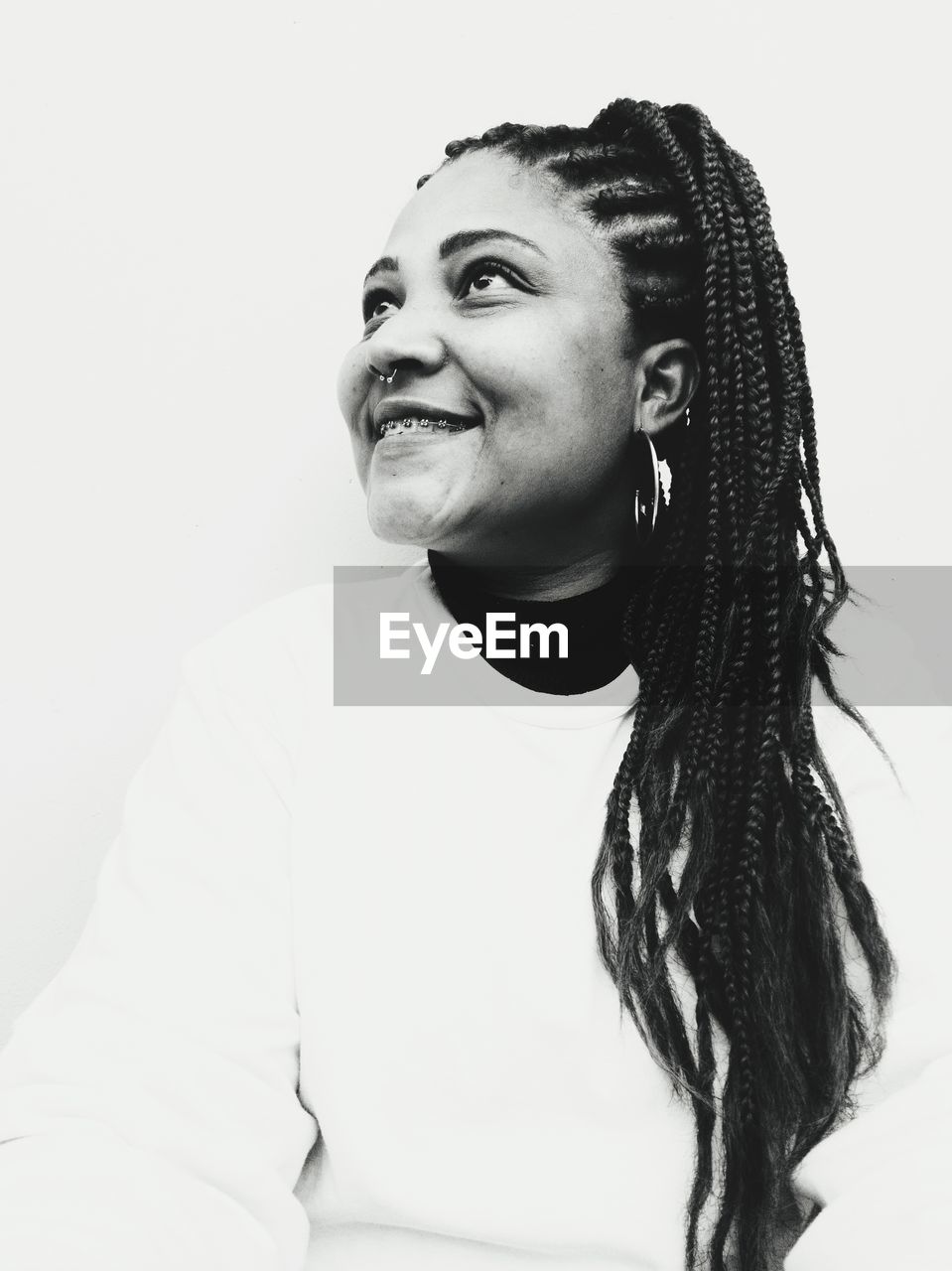 PORTRAIT OF SMILING WOMAN AGAINST WHITE BACKGROUND