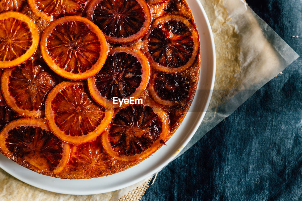 High angle view of dessert in plate on table, blood orange syrup cake