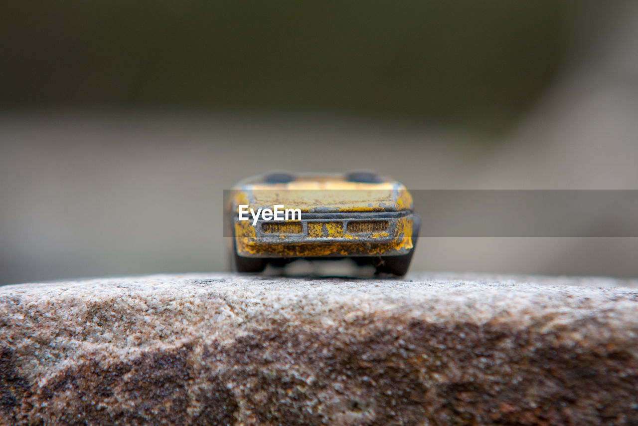 Close-up of rusty toy car on rock