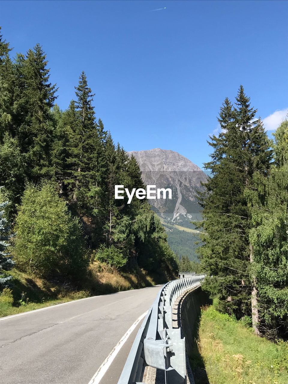 ROAD BY TREES ON MOUNTAIN AGAINST SKY