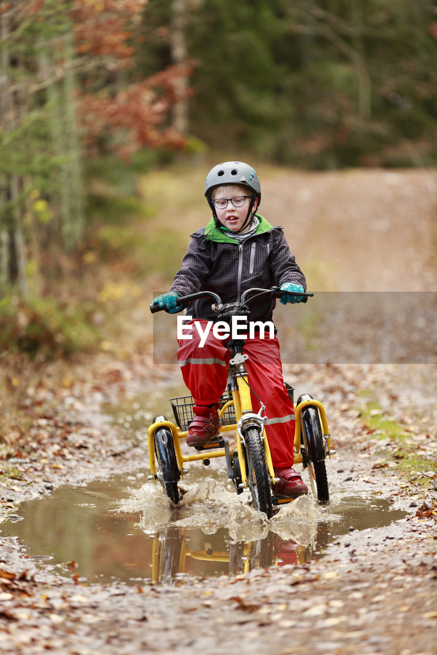 Boy cycling through forest