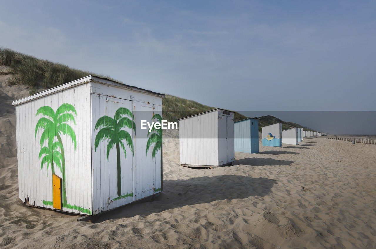 BEACH HUTS BY SEA AGAINST SKY