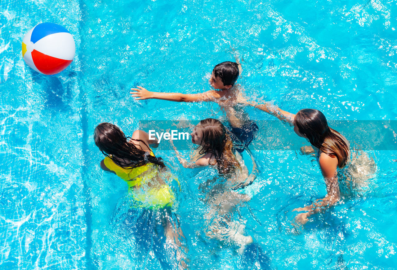 high angle view of shirtless boy swimming in pool