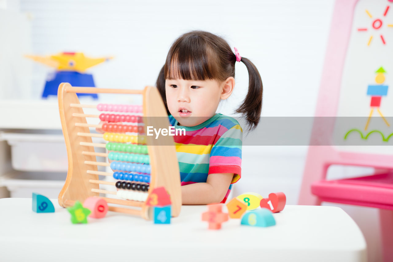 Young girl learn counting by using abacus for homeschooling